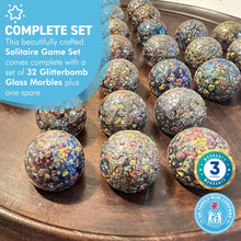 Load image into Gallery viewer, 30cm Diameter WOODEN SOLITAIRE BOARD GAME with GLITTERBOMB GLASS MARBLES | classic wooden solitaire game | strategy board game | family board game | games for one | board games