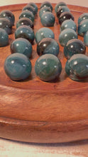 Load and play video in Gallery viewer, 30cm Diameter MANGO WOOD SOLITAIRE BOARD GAME with Midnight Blue Glass Marbles | |classic wooden solitaire game | strategy board game | family board game | games for one | board games