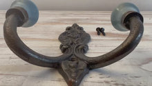Load and play video in Gallery viewer, CAST IRON FRENCH STYLE DOUBLE ORNATE HOOKS | Duck Egg Blue Ceramic Ball Tops | Cloakroom Hook | Decorative Double Hook, hat and coat hook | 15cm x 11cm.
